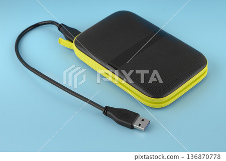 external hard drive, external drive with USB cable, on a blue background 136870778