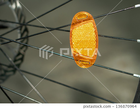 a reflector attached to a bicycle wheel. a reflector attached to a bicycle wheel. 136870964
