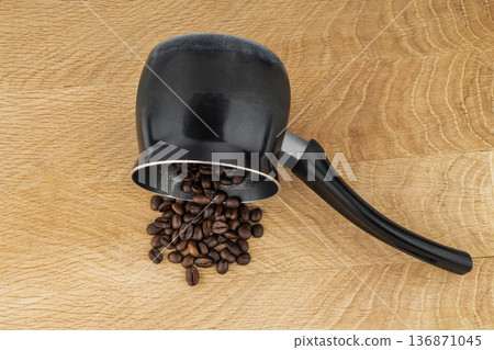 Turk for making coffee, and coffee beans on a wooden board Turk for making coffee, and coffee beans on a wooden board 136871045