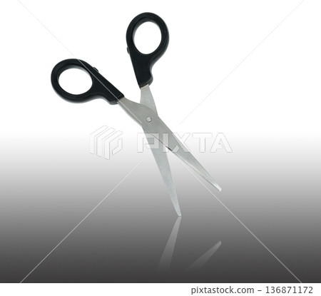scissors with black handle and mirror reflection on a white background in isolation 136871172