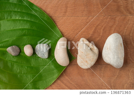 Green Leaves, Wayward Hosts and Stones of Various Velecheny on the Background of a Wooden Board Green Leaves, Wayward Hosts and Stones of Various Velecheny on the Background of a Wooden Board 136871363
