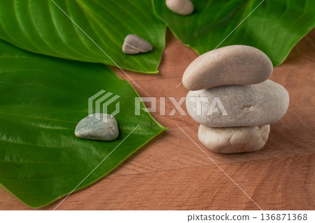 Green Leaves, Wayward Hosts and Stones of Various Velecheny on the Background of a Wooden Board Green Leaves, Wayward Hosts and Stones of Various Velecheny on the Background of a Wooden Board 136871368
