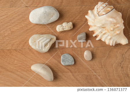 Smooth stones of various sizes and shells are scattered on the wood board Smooth stones of various sizes and shells are scattered on the wood board 136871377