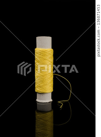 A skein of thread, a spool of thread for sewing, on a black background isolated with reflection A skein of thread, a spool of thread for sewing, on a black background isolated with reflection 136871453