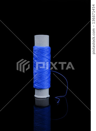 A skein of thread, a spool of thread for sewing, on a black background isolated with reflection A skein of thread, a spool of thread for sewing, on a black background isolated with reflection 136871454