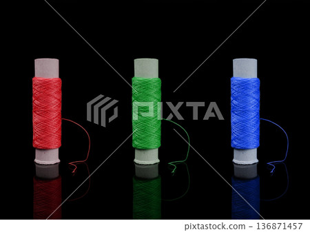 A skein of thread, a spool of thread for sewing, on a black background isolated with reflection 136871457