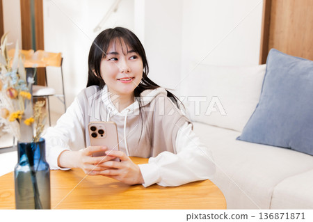 A woman watching a smartphone A woman watching a smartphone 136871871