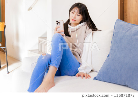 A woman watching a smartphone A woman watching a smartphone 136871872