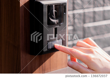Finger pushing the doorbell on the front door Finger pushing the doorbell on the front door 136872037