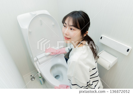 年輕女子正在打掃廁所 年輕女子正在打掃廁所 136872052