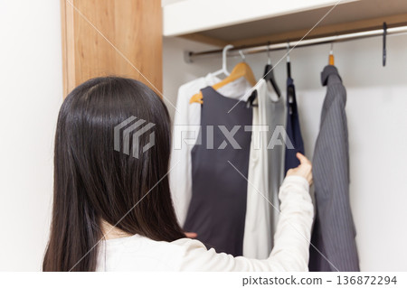 女人從衣櫃裡拿起衣服 136872294