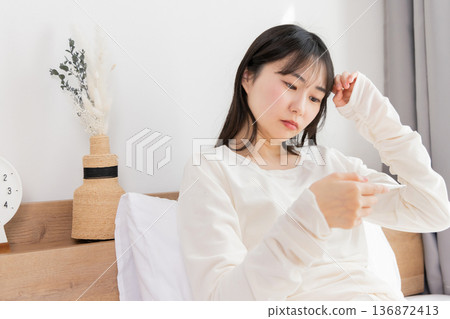 A woman who measures fever with a thermometer 136872413