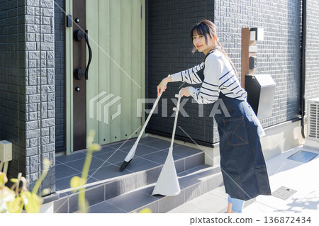 婦女們正在打掃花園,打掃入口 婦女們正在打掃花園,打掃入口 136872434