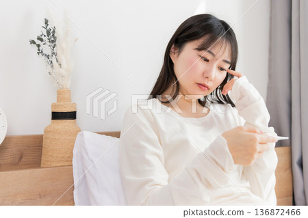 用溫度計測量發燒的女人 用溫度計測量發燒的女人 136872466