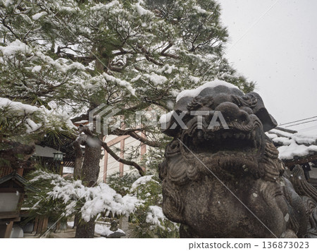 在冬日靜謐的寺廟庭院裡,白雪覆蓋著守護獅子雕像。 在冬日靜謐的寺廟庭院裡,白雪覆蓋著守護獅子雕像。 136873023