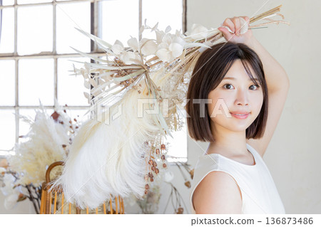 One-piece woman holding a bouquet of dried flowers One-piece woman holding a bouquet of dried flowers 136873486