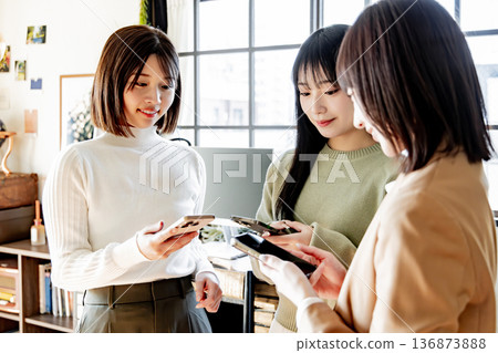 三個女人在使用智慧型手機 136873888