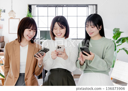 Three women using smartphones Three women using smartphones 136873906