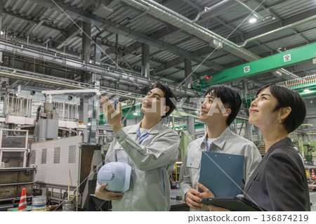 A female business person and a male worker inspecting a factory A female business person and a male worker inspecting a factory 136874219