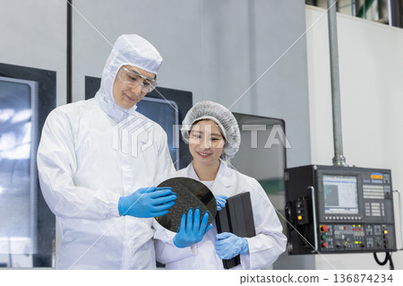 Worker in protective clothing using tablet PC in factory 136874234