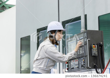 一名女工在工廠控制面板前工作 一名女工在工廠控制面板前工作 136874241
