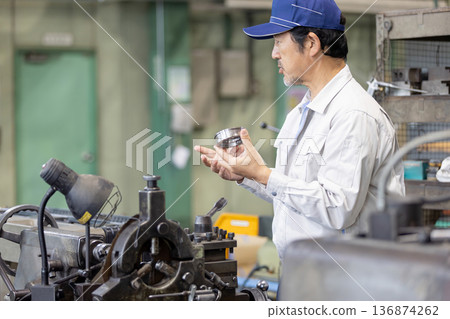 Workers inspecting products at a factory Workers inspecting products at a factory 136874262