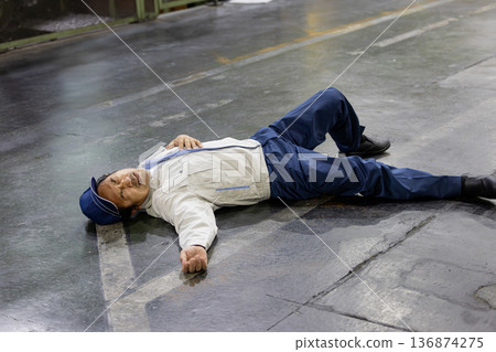 Worker collapses on factory floor Worker collapses on factory floor 136874275