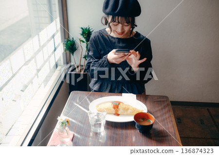 A Japanese woman in her 30s taking a photo of omurice with her smartphone A Japanese woman in her 30s taking a photo of omurice with her smartphone 136874323