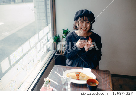 A Japanese woman in her 30s taking a photo of omurice with her smartphone A Japanese woman in her 30s taking a photo of omurice with her smartphone 136874327