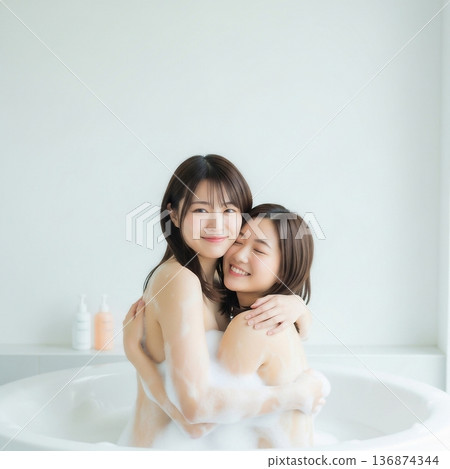 兩個年輕女子在泡泡浴中擁抱在一起 136874344