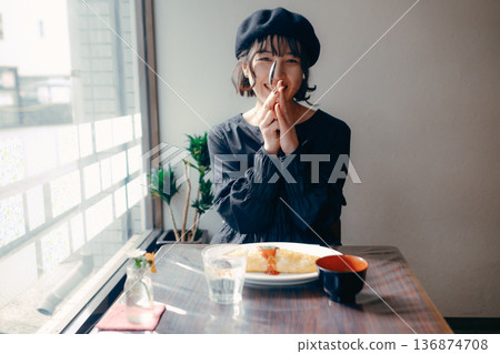 A Japanese woman in her 30s saying "itadakimasu" in front of an omelet rice A Japanese woman in her 30s saying "itadakimasu" in front of an omelet rice 136874708