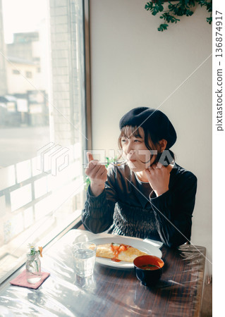A Japanese woman in her 30s eating omurice, lunch scene A Japanese woman in her 30s eating omurice, lunch scene 136874917