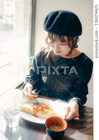 A Japanese woman in her 30s eating omurice, lunch scene 136874925