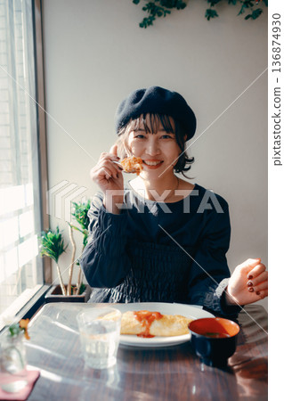 A Japanese woman in her 30s eating omurice, lunch scene 136874930