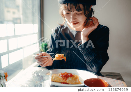 一位三十多歲的日本女性正在吃蛋包飯,午餐場景 一位三十多歲的日本女性正在吃蛋包飯,午餐場景 136874939