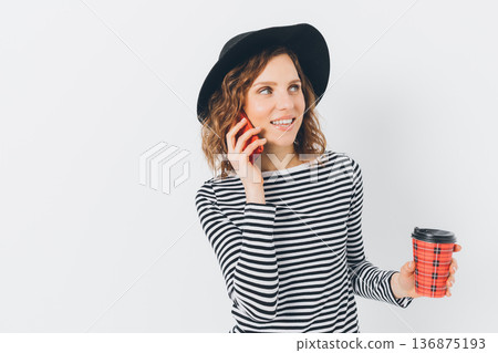 Woman is talking on her cell phone while holding a red cup 136875193