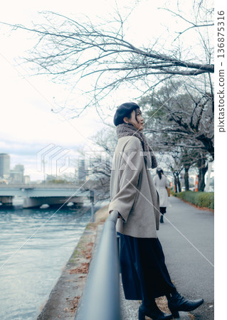 一位三十多歲的日本女子在冬日的河邊仰望天空。 136875316