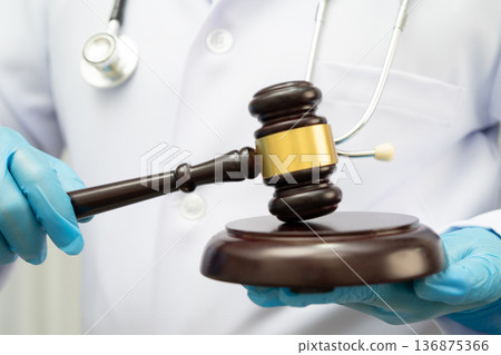 Doctor holding judge gavel, forensic medicine, medical law and crime justice. Doctor holding judge gavel, forensic medicine, medical law and crime justice. 136875366