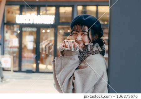A Japanese woman in her 30s enjoying sweets in a winter town A Japanese woman in her 30s enjoying sweets in a winter town 136875676
