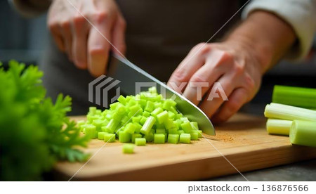 A person preparing fresh green vegetables on a cutting board, emphasizing healthy eating and detox for National Celery Month 136876566