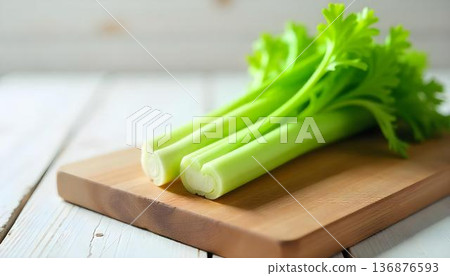 Crisp celery arranged on a wooden cutting board, promoting wellness and healthy snacking during National Celery Month 136876593