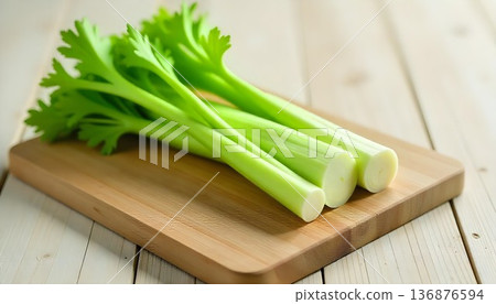 Fresh green celery stalks on a wooden cutting board, highlighting healthy eating for National Celery Month 136876594