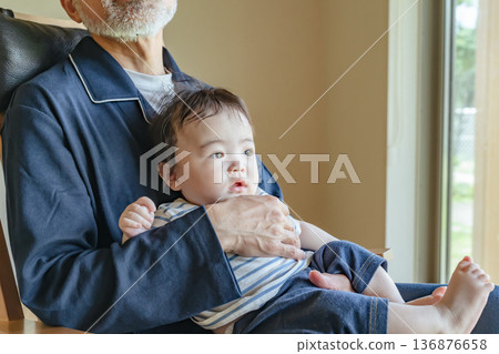 Senior man holding a baby 136876658