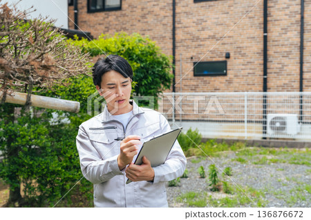 Male worker inspecting garden trees 136876672