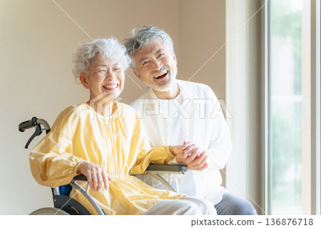 Senior man caring for a senior woman in a wheelchair Senior man caring for a senior woman in a wheelchair 136876718