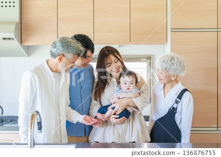 Smiling three-generation family surrounding a baby Smiling three-generation family surrounding a baby 136876755