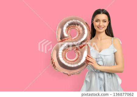 Woman smiles with a big balloon shaped like an 8 Woman smiles with a big balloon shaped like an 8 136877062