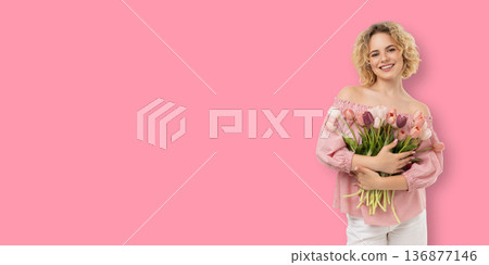 A young woman holds a bouquet of flowers while smiling A young woman holds a bouquet of flowers while smiling 136877146