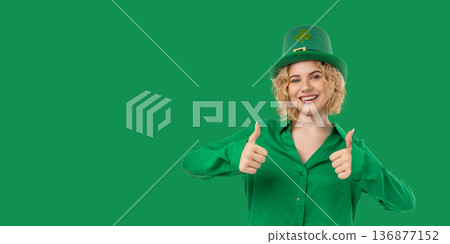 Woman smiles and gives thumbs up while wearing green clothing 136877152