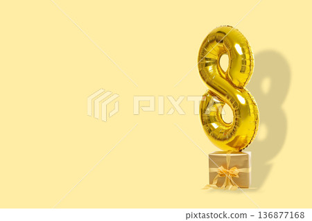 A gold number 8 balloon sits next to a gift A gold number 8 balloon sits next to a gift 136877168